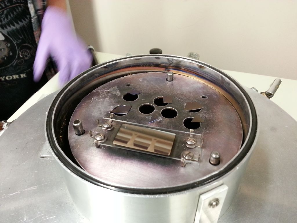 Place the chips over large holes (rough side down) in the vacuum deposition chamber, depositing aluminum.